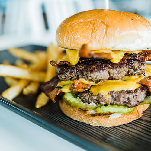 A double burger served with fries