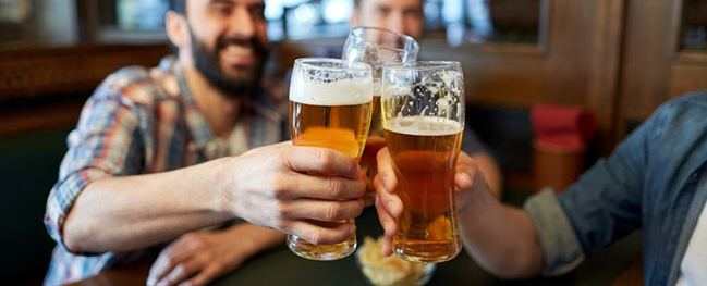 Friends raising glasses of beer at the table
