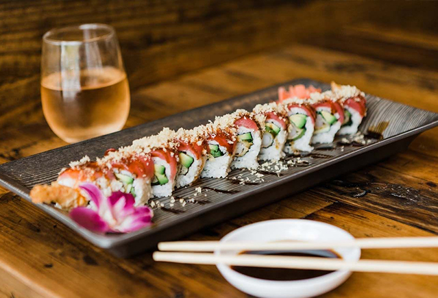 Sushi rolls and a glass of wine on a table
