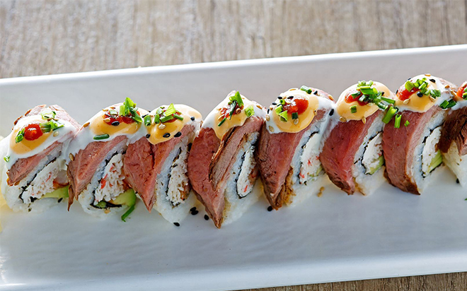 Sushi rolls arranged on a white serving platter