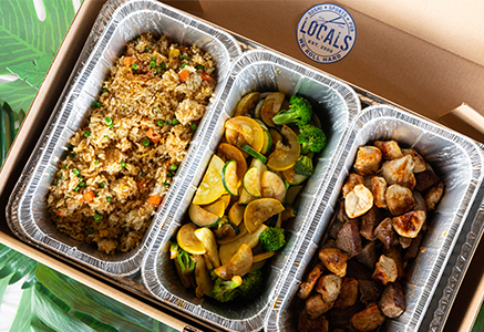 Catering trays filled with fried rice, vegetables and grilled meat