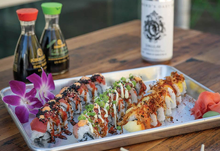 Sushi rolls served with soy sauce and a bottle of sake