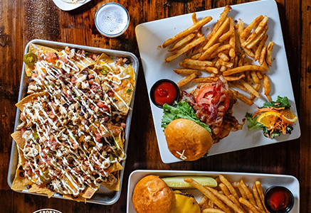 Sushi, burgers and fries arranged on a restaurant table