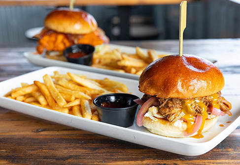 A burger topped with melted cheese and served with fries