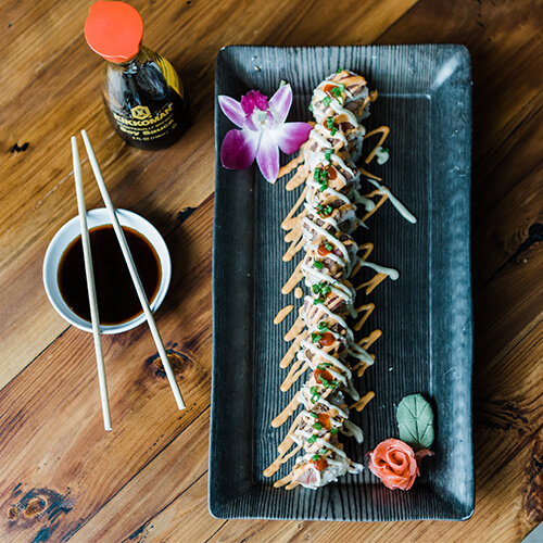 Sushi rolls served on a long black platter