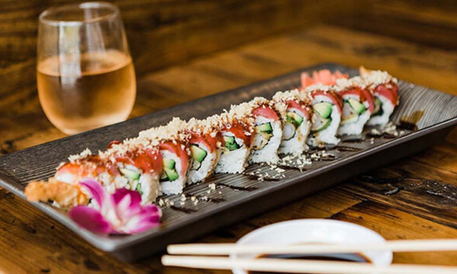 A sushi platter and a glass of wine
