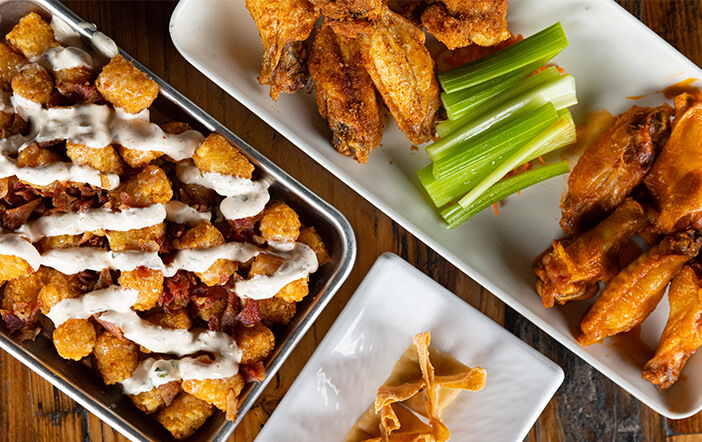 Sushi rolls, chicken wings and fried appetizers ready to share