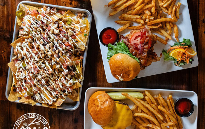Sushi, burgers and fries served on a restaurant table