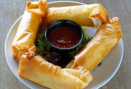 Fried appetizers arranged around a bowl of dipping sauce