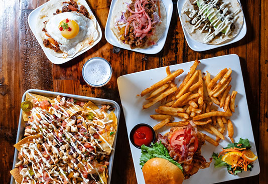 Sushi, burgers, fries and small plates arranged on a table