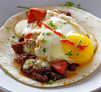 An open taco topped with an egg and sliced avocado